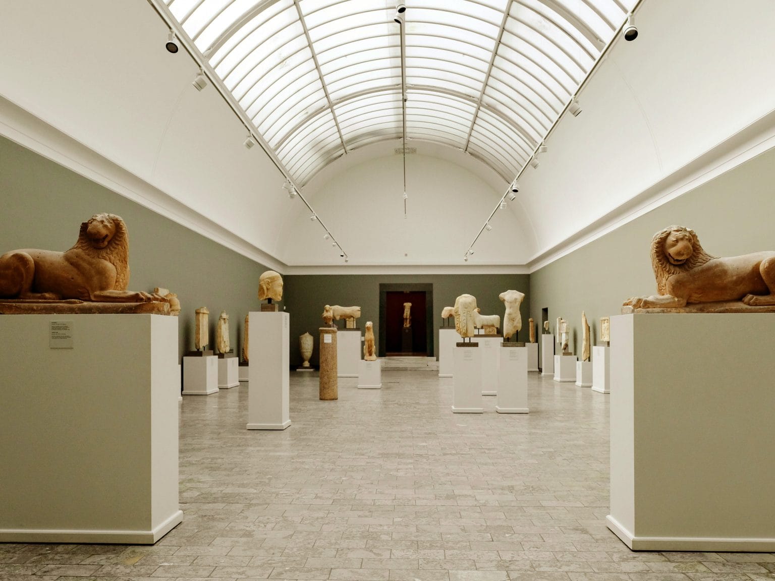 Sala de um museu com várias estátuas e esculturas